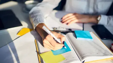 Person writing in a notebook.