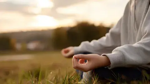 Person meditating in the fields. 