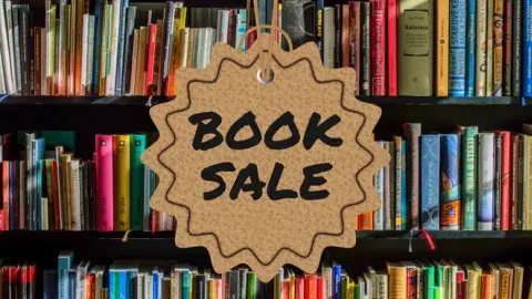 bookshelf with sign reading book sale