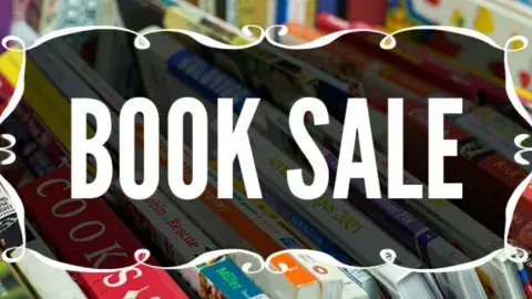 Words Book Sale in a stylish frame on the background of books of various colors