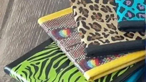 Five wallets of different colors and designs made of duct tape.
