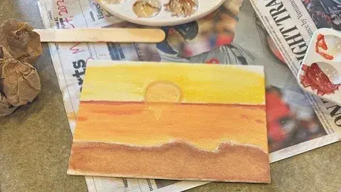 A painting laying on top of a newspaper.