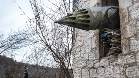 missile protrudes from window of brick building 