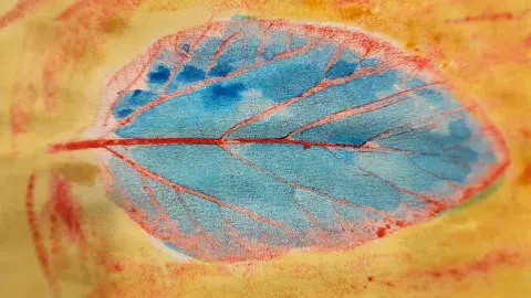 Leaf rubbing with blue and red crayons and yellow watercolor paint