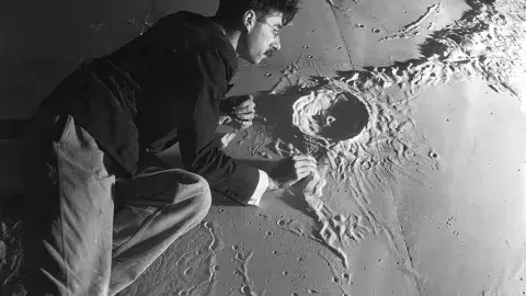 Person with plaster scale model of moon