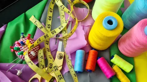 Sewing tools and fabric cut from a pattern.