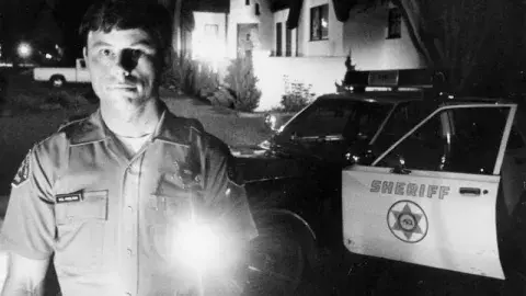cop with flashlight at night