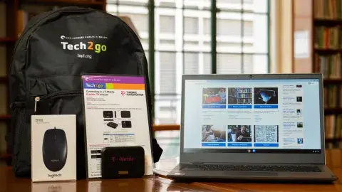 laptop with backpack and user manuals