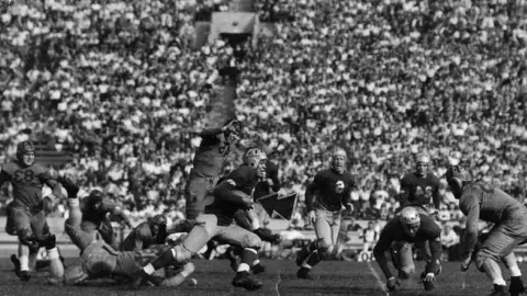 College football game where UCLA players make an offensive play.