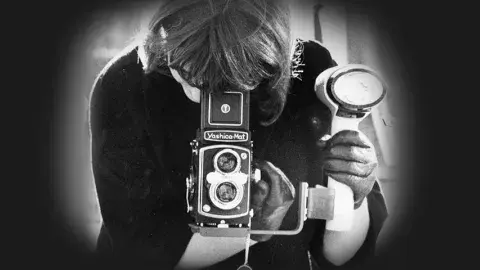 Women using a twin lens camera with a waist-level viewfinder.