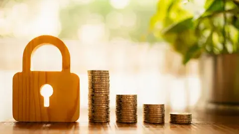 Stacks of coins next to a padlock