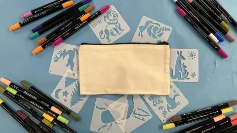 Canvas pouch surrounded by stencils and markers