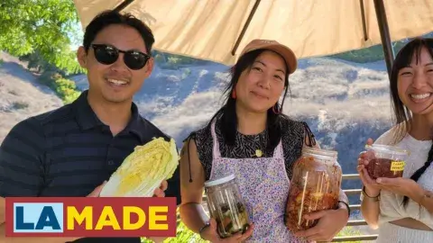 three people holding up jars and vegetables