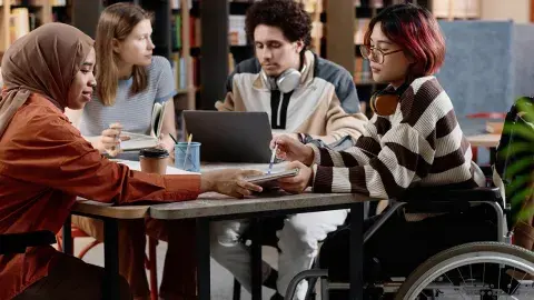 Teens studying at a table together.