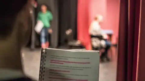 person holding highlighted script 