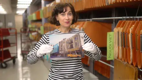Wendy holding up a photo from the Jay More collection