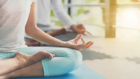 person sits in lotus pose