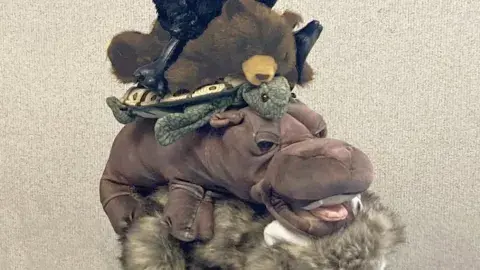 A stack of puppets atop one another in the style of the "Town Musicians of Bremen"