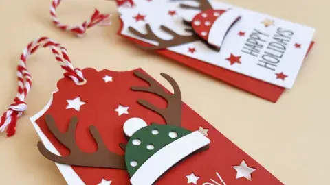 DYI Cricut made present tags featuring festive hats with antlers expressing "Happy Holidays"" 