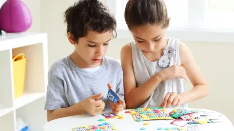 Two young children playing a game of bingo.