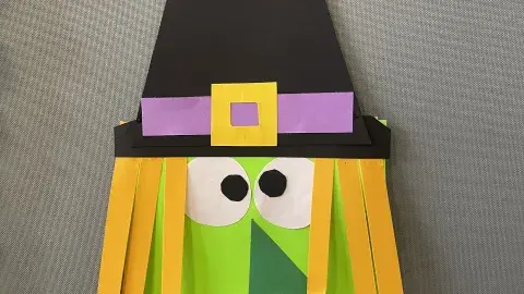 Paper craft of a green witch. 