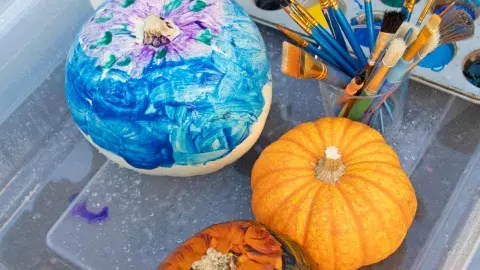 painted pumpkins in a tub with paint
