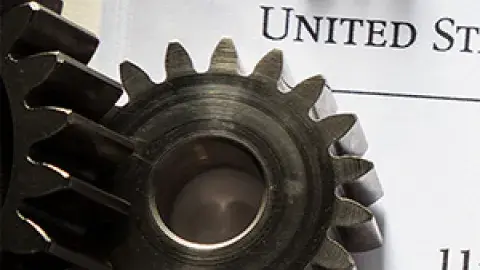 gears with paper work in the background representing patents