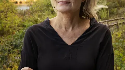 Jennifer Egan arms crossed in a black dress 
