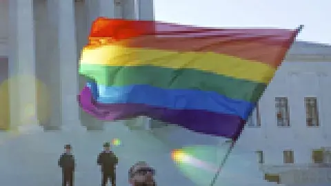 man waving rainbow flag