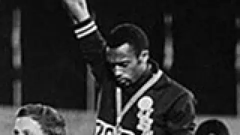 Tommie Smith and John Carlos raising their fists with bowed heads while receiving the gold and bronze medals
