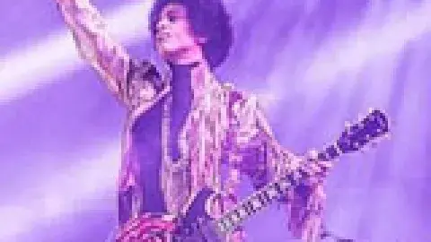 Prince in concert holding a guitar