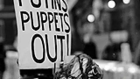 photo of a sign that reads: Putins Puppets Out