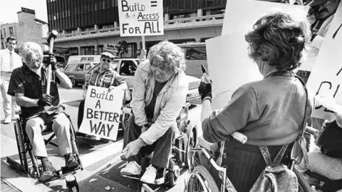 people in wheel chairs at a protest