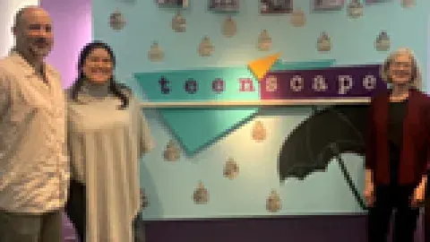 3 journalists in front of teenscape sign