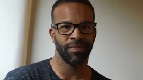 Douglas Kearney wearing glasses and smiling