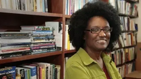 Harryette Mullen next to book shelves