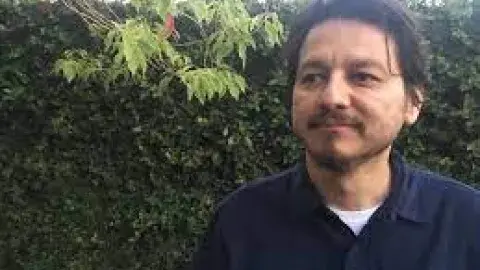 William Archila near a tall green shrub